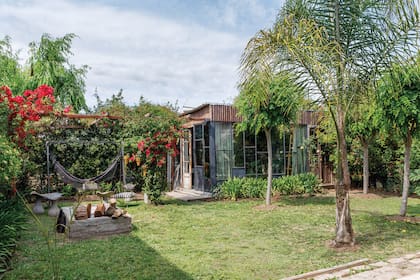 En el jardín que lleva al taller de Marina, hamaca paraguaya y troncos.