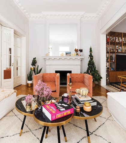 En el living, blanco impecable, sobresalen tres mesas bajas de mármol pulido y dos sillas cubo de pana de Bull Buenos Aires. Detrás, el árbol navideño, de las ambientadoras Sol y Ángeles Rodríguez Oneto, amigas de la dueña de casa.