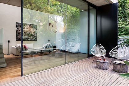 Sillón realizado por Roberto Michaelis vestido con almohadones de Marimekko. Cuadro del artista Alejandro Arguelles y réplica de un móvil de Alexander Calder, por Jorge Bascoy. Lámpara de pie de aluminio con difusor ‘Hi Hat’ (iMdi)