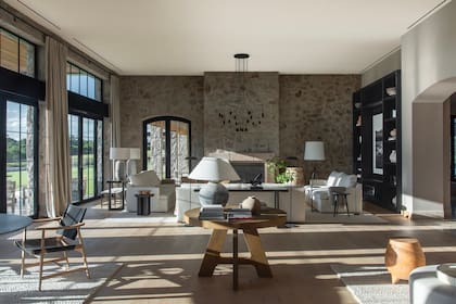En el living (con techos de 4,30 metros de altura) como en el comedor, se instalaron sendas lámparas de techo ‘Wireflow’ (Vibia), diseñadas para estar presentes y ausentes a la vez. Las lámparas de pie negras también son de Vibia. Todos los pisos se hicieron en entablonado de roble.