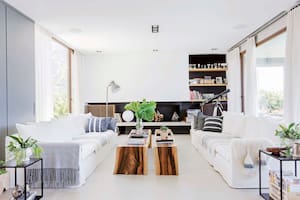 En el living, el hogar fue construido sobre una franja negra que va de pared a pared. Una chapa hace de pestaña de apertura, y su base es una losa suelta que funciona como leñero.