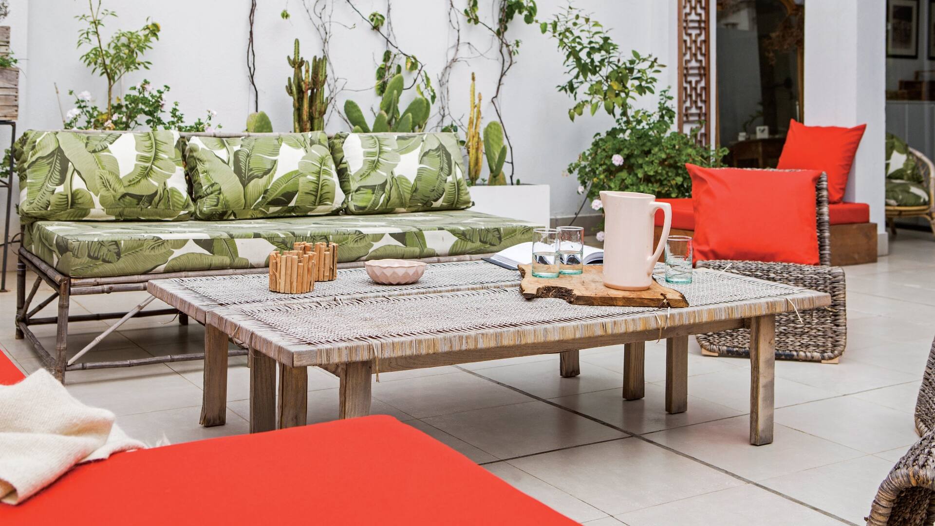 En el living exterior, sofá y trío de sillones de ratán (Ikea) con almohadones hechos a medida (Anne y Flor, Deco en Telas). Una vieja tabla de madera traída desde Francia acompaña las reuniones entre amigos.
