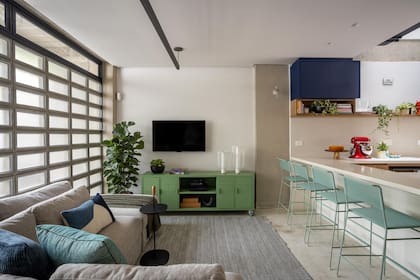 En el living, pocos objetos, todos con función o significado definido. El área social tiene piso de terrazo, acá cubierto con una alfombra.