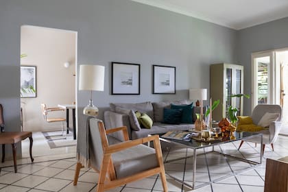 En el living, sofá de dos cuerpos (IO Disano) con almohadones (Tapicería Carlos Méndez), butaca de pana heredada, sillón con estructura de madera (IO Disano). Vitrina (Distribuidora Paraná).
