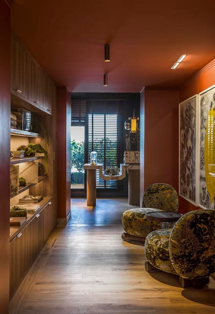 En el pasillo que lleva al atelier botánico, mueble (Mobiline) revestido con melamina 'Scotch'. Sillones 'Brønz' (Barn). Obras de Adriana Carambia (Diderot.art).