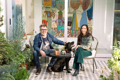 En el patio interno junto a Batata, su perro. Detrás asoma una de las tantas obras de Milo que cuelgan en la casa. Del 24 al 27 de agosto, la pareja presentará sus respectivos trabajos en la feria BADA.