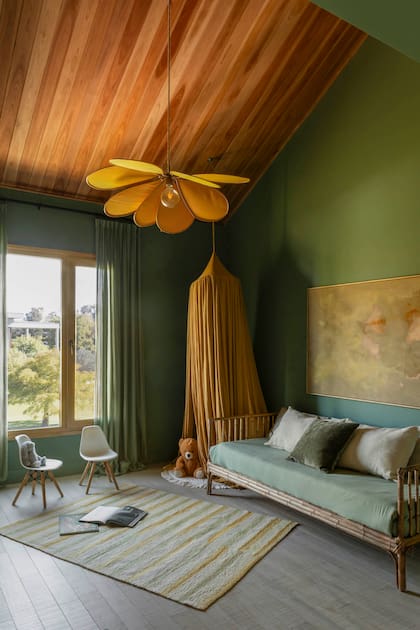En el playroom verde, alfombra (Awanay), lámpara colgante (Bless Home), cortina colgante (Deco Trulala), almohadones (Lote Propio) y obra de arte realizada con tintes naturales (Studio Lola Pérez).