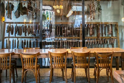 En El Preferido, la cava vidriada para los embutidos es protagonista del salón