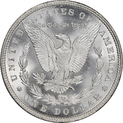 En el reverso, el diseño del dólar Morgan presenta un águila calva con las alas extendidas, sosteniendo flechas y una rama de olivo, símbolos de guerra y paz