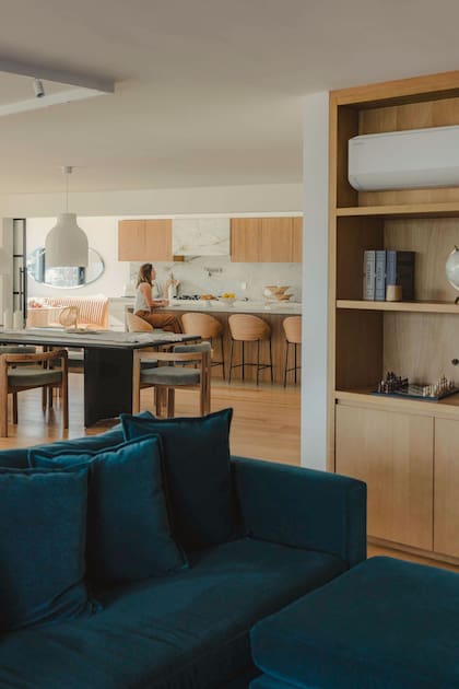 En el sector de la TV, se diseñó un sillón en pana azul que se destaca de la paleta de neutros del resto del living.