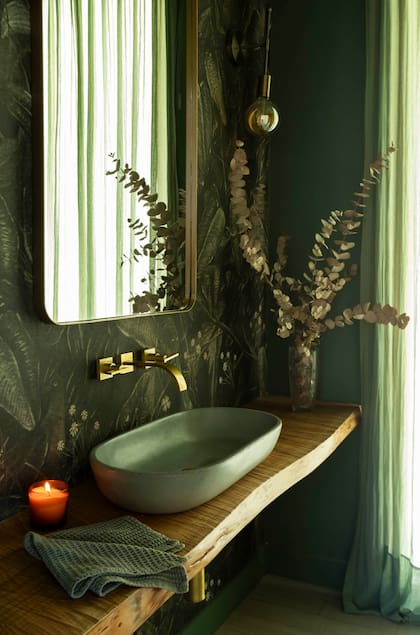 En el toilette ambientado por Sofía Díaz de Vivar, de Belgika Home, empapelado (Mercedes Costal), bacha (Cóncavo), cortina de gasa (Abax), espejo (Antiguo Vagón Deco) y apliques (Hado De Luz). Vela (Bohemia Velas).