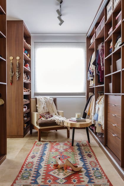 En el vestidor de la suite, kilim antiguo heredado, sillón ‘Gaucho Pop’ (Eugenio Aguirre), mesa ‘Rodaja’ con patas de hierro (Sol Palou). Casa en Nordelta, de Lorena Pedace
