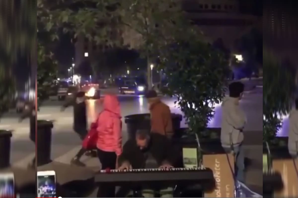 En el video se puede ver cómo un músico continúa tocando muy tranquilo mientras detrás hay enfrentamientos con la policía