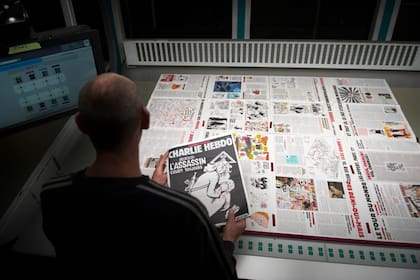 En esta foto de 2016, un trabajador de una imprenta cerca de París sostiene una copia de la última edición de la revista satírica francesa Charlie Hebdo