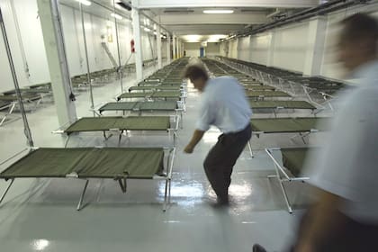 En esta foto de agosto de 2003, empleados verifican catres del ejército para utilizar en un refugio refrigerado, el en el suburbio de Rungis, en París