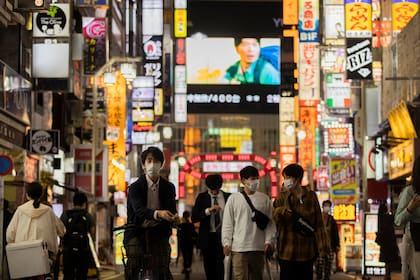 En esta foto de archivo del 1 de octubre de 2021, la gente camina por el famoso distrito de entretenimiento de Kabukicho en Tokio la primera noche del levantamiento del estado de emergencia por coronavirus por parte del gobierno.