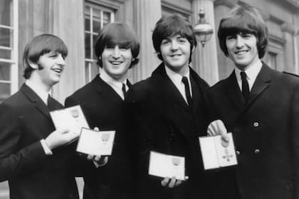 En esta foto de archivo del 26 de octubre de 1965, The Beatles, de izquierda a derecha: Ringo Starr, John Lennon, Paul McCartney y George Harrison sonríen mientras muestran las medallas de Miembro de la Orden del Imperio Británico que les entregó la reina Isabel II