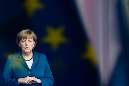 En esta foto de archivo del 3 de junio de 2013, la canciller alemana Angela Merkel está detrás de una ventana que refleja la bandera de la Unión Europea