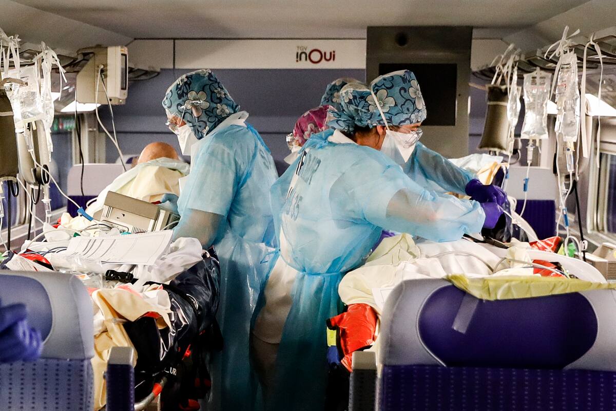 En esta foto de archivo tomada el 1 de abril de 2020, el personal médico instala pacientes infectados con coronavirus a bordo de un tren de alta velocidad TGV en la estación de trenes Gare dAusterlitz en París