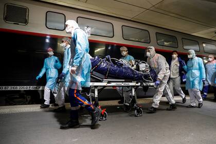 En esta foto de archivo tomada el 1 de abril de 2020, el personal médico embarcó a un paciente infectado con coronavirus a bordo de un tren de alta velocidad TGV en la estación de tren Gare dAusterlitz en París