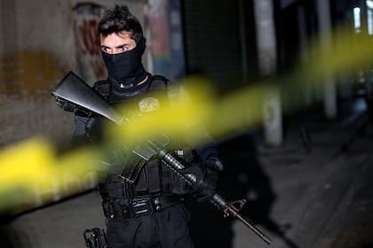 En esta foto de archivo tomada el 1 de octubre de 2019, un policía participa en la reconstrucción del asesinato de Agatha Sales Felix, de ocho años, en el complejo de favelas Alemao, Río de Janeiro, Brasil