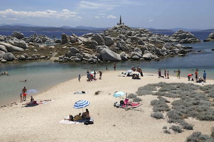 En esta foto de archivo tomada el 10 de julio de 2022, los turistas se paran en una playa de arena blanca en las islas Lavezzi, cerca de Bonifacio en la isla mediterránea francesa de Córcega