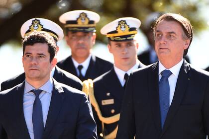 En esta foto de archivo tomada el 11 de junio de 2019, el presidente brasileño, Jair Bolsonaro y su ministro de Justicia, Sergio Moro, llegan a la sede de la Infantería de Marina de Brasil en Brasilia