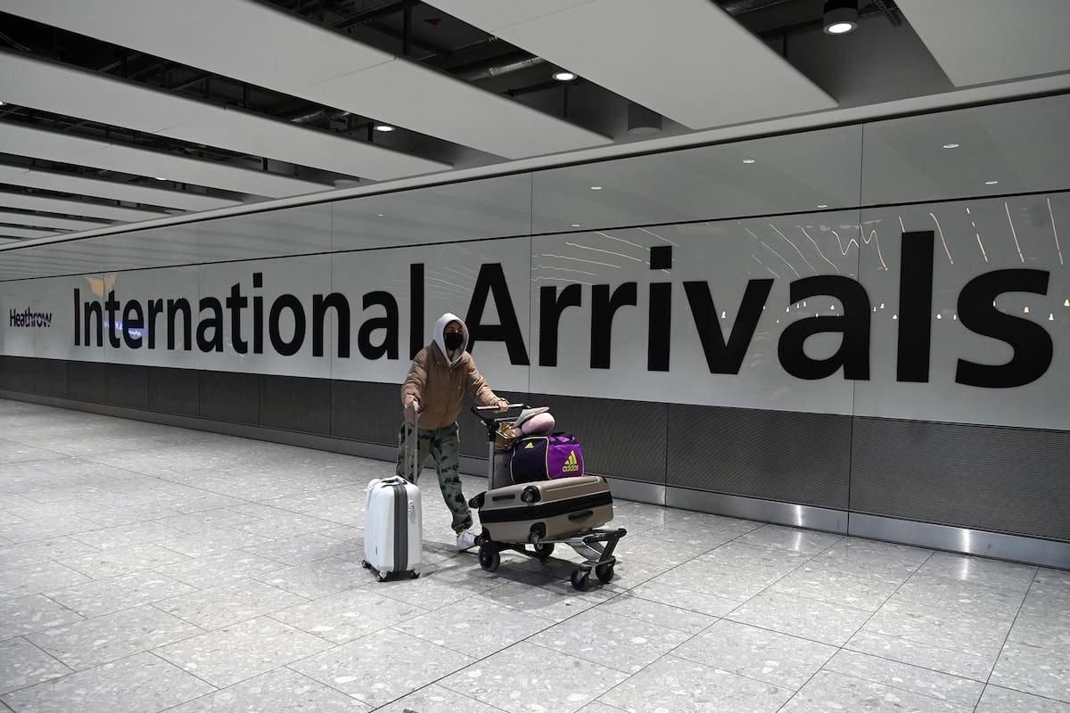 En esta foto de archivo tomada el 15 de enero de 2021, un pasajero con una máscara facial como medida de precaución contra el Covid-19, camina por la sala de llegadas después de aterrizar en el aeropuerto de Heathrow en el oeste de Londres