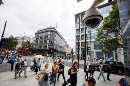 En esta foto de archivo tomada el 16 de agosto de 2019, la gente pasa frente a una cámara de CCTV que funciona en Oxford Street en Londres