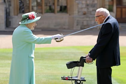 En esta foto de archivo tomada el 17 de julio de 2020, la reina Isabel II de Gran Bretaña usa la espada que perteneció a su padre, Jorge VI, mientras confiere el Honor de Caballería al veterano capitán de 100 años Tom Moore