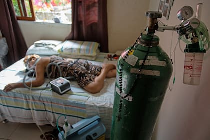 En esta foto de archivo tomada el 2 de febrero de 2021 Dilza Maria Pereira Rodrigues, de 71 años, recibe tratamiento por Covid-19 en su casa luego de 15 días de tratamiento en el hospital de Manaus, Brasil
