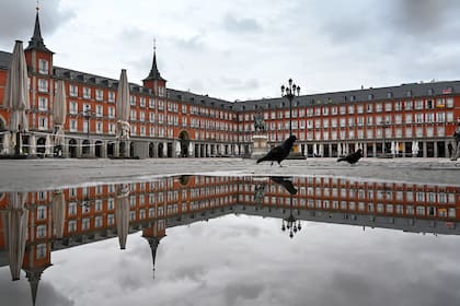 En esta foto de archivo tomada el 21 de abril de 2020, una persona cruza la desierta Plaza Mayor de Madrid en medio de un cierre nacional para combatir la propagación del nuevo coronavirus
