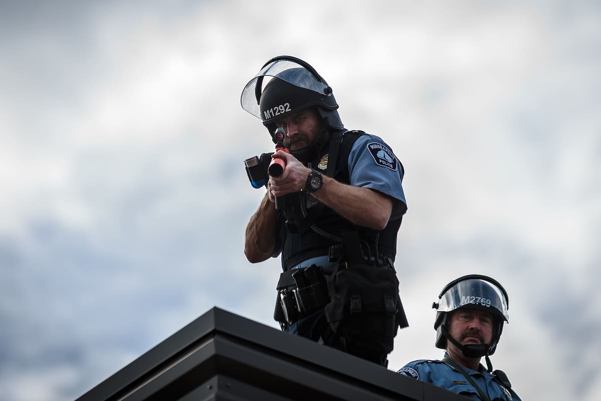 En esta foto de archivo tomada el 27 de mayo de 2020, dos policías de Minneapolis se paran en el techo del Tercer Recinto Policial sosteniendo un proyectil durante una manifestación en un llamado a la justicia para George Floyd