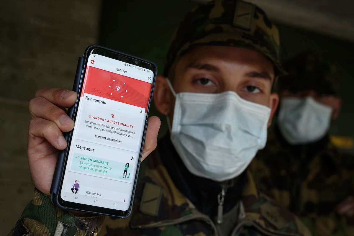 En esta foto de archivo tomada el 30 de abril, un soldado suizo con una mascarilla posa con su teléfono inteligente en el cuartel del ejército suizo de Chamblon, durante la prueba de una aplicación creada por el Instituto Federal Suizo de Tecnología de Lausana (EPFL) que podría YUDAR a localizar a a