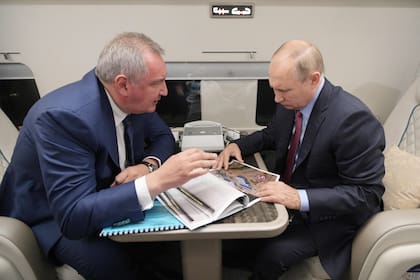 En esta foto de archivo tomada el 4 de septiembre de 2021, el presidente ruso, Vladimir Putin (der.), habla con el jefe de la agencia espacial rusa Roscosmos, Dmitry Rogozin, durante un vuelo al cosmódromo de Vostochny, en la región de Amur