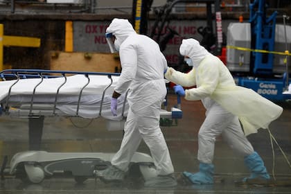 En esta foto de archivo tomada el 9 de abril de 2020, el personal médico traslada a un paciente fallecido a un camión refrigerado que servía como morgue provisional en el Brooklyn Hospital Center en la ciudad de Nueva York