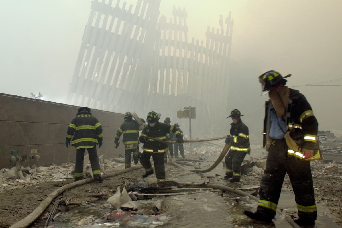 En esta foto del 11 de septiembre de 2001, los bomberos trabajan bajo los parteluces destruidos, los puntales verticales que en su día sostenían los muros exteriores de las torres del World Trade Center, tras el ataque terrorista contra las torres gemelas en Nueva York