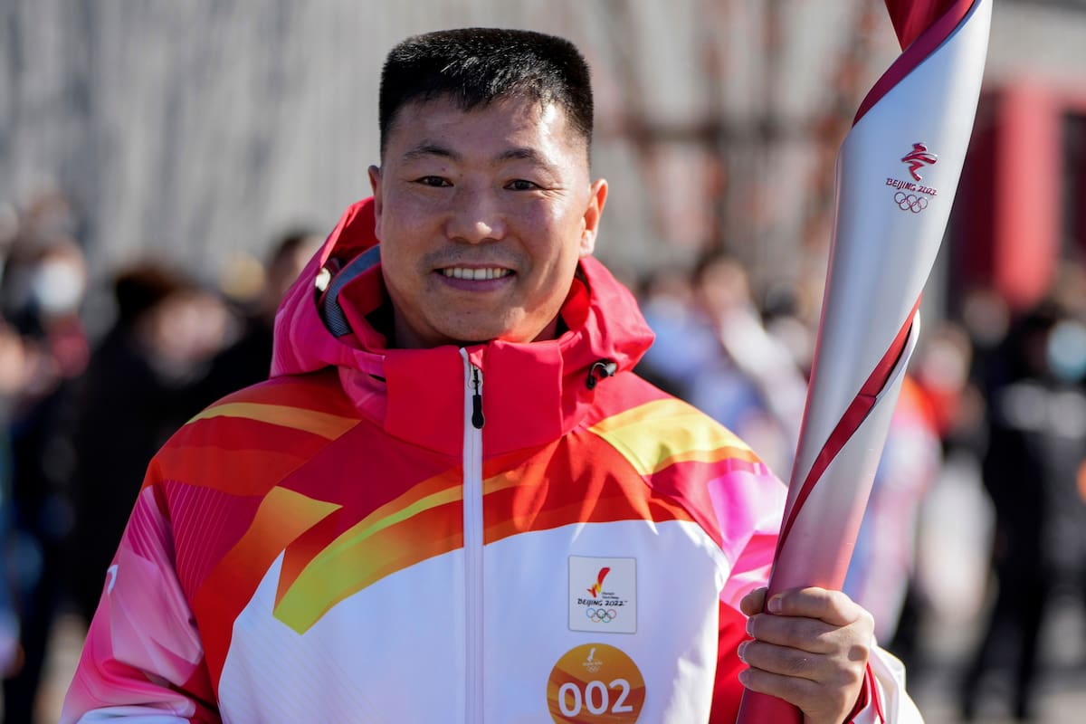 En esta foto del 2 de febrero de 2022, publicada por la Agencia de Noticias Xinhua, el portador de la antorcha Qi Fabao participa en el relevo de la antorcha de los Juegos Olímpicos de Invierno de 2022 en un parque olímpico de Pekín