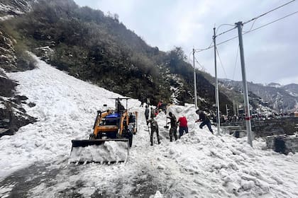 En esta foto difundida por el Ejército indio, soldados limpian la nieve de una avalancha cerca del paso de montaña de Nathu La, en el estado indio de Sikkim, el martes 4 de abril de 2023.
