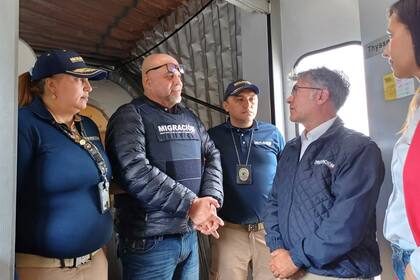 En esta foto difundido por Migración Colombia, funcionarios de migración reciben al líder exparamilitar Salvatore Mancuso en la puerta del avión a su llegada desde Estados Unidos, desde donde fue deportado tras cumplir condena por tráfico de drogas, en Bogotá, Colombia, el martes 27 de febrero de 2024. (Migración Colombia vía AP)
