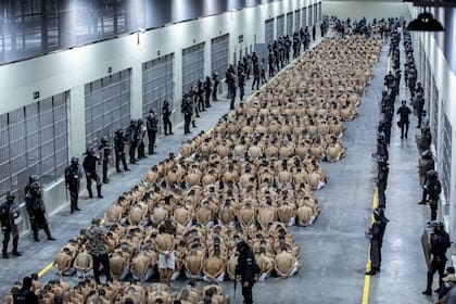 En esta foto proporcionada por la oficina de prensa de la presidencia de El Salvador, los presos identificados por las autoridades como pandilleros están sentados en el piso de la prisión del Centro de Confinamiento contra el Terrorismo en Tecoluca, El Salvador, el miércoles 15 de marzo de 2023.