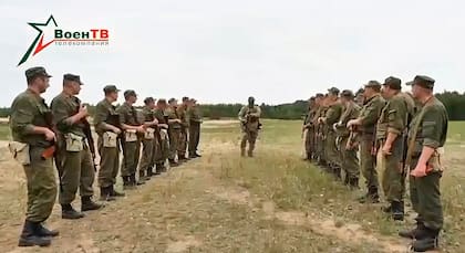 En esta foto tomada de un video difundido por el Ministerio de Defensa de Bielorrusia vía VoenTV el viernes 14 de julio de 2023, un instructor del contratista militar Wagner, centro, conversa con soldados bielorrusos durante un entrenamiento cerca de la aldea de Tsel, al sureste de Minsk, Bielorrusia.