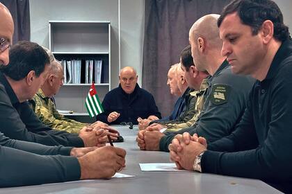 En esta foto tomada de un video publicado por el Centro de Información del Presidente de la República de Abjasia el lunes 18 de noviembre de 2024, el presidente de Abjasia, Aslan Bzhania, en el centro, preside una reunión del Consejo de Seguridad en la aldea de Tamishi, en la provincia separatista georgiana de Abjasia. (Centro de Información del Presidente de la República de Abjasia vía AP)