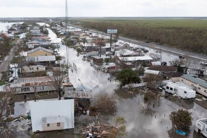 En esta fotografía aérea tomada con un dron, se muestran inundaciones que rodean viviendas dañadas el martes 31 de agosto de 2021, en el condado de Lafourche, Luisiana, luego del paso del huracán Ida. (AP Foto/Steve Helber)