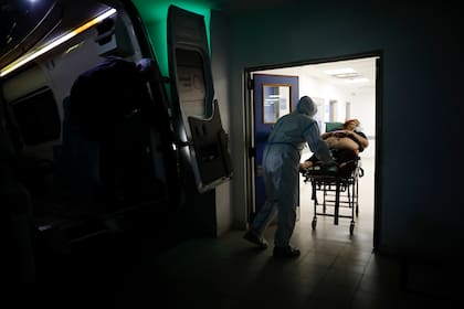 En esta fotografía de archivo del 1 de mayo de 2021, un trabajador de la salud traslada a una mujer sospechosa de tener Covid-19 en el Hospital Dr. Norberto Raúl Piacentini en Lomas de Zamora