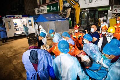 En esta fotografía difundida por la Agencia de Noticias Xinhua, trabajadores médicos retiran a la décima sobreviviente luego de que pasó 132 horas atrapada entre los escombros de un edificio que se vino abajo, el jueves 5 de mayo de 2022, en Changsha, provincia de Hunan, en el centro de China. (Chen Sihan/Xinhua vía AP)