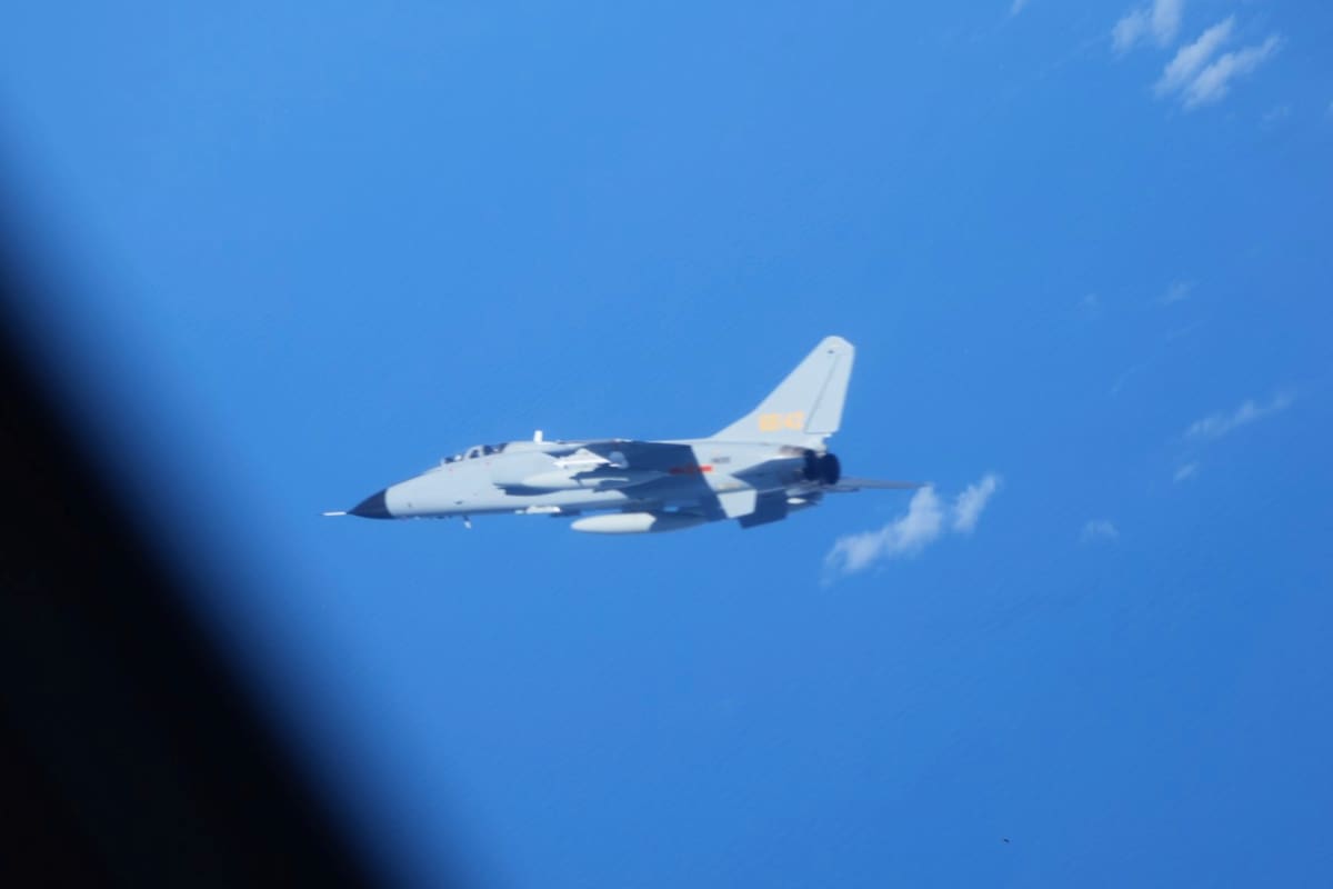 En esta fotografía proporcionada por el Ministerio de Defensa de Japón, se ve un cazabombardero chino JH-7, cerca de un avión de inteligencia electrónica YS-11EB, visto parcialmente a la izquierda, de la Fuerza de Autodefensa Aérea de Japón sobre el Mar de China Oriental, el 9 de julio de 2025