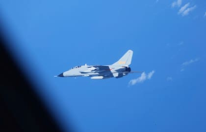 En esta fotografía proporcionada por el Ministerio de Defensa de Japón, se ve un cazabombardero chino JH-7, en el centro, cerca de un avión de inteligencia electrónica YS-11EB, visto parcialmente a la izquierda, de la Fuerza de Autodefensa Aérea de Japón sobre el Mar de China Oriental, el 9 de julio de 2025. (Ministerio de Defensa de Japón vía AP)