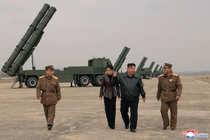 En esta fotografía, proporcionada por el gobierno norcoreano, el gobernante del país, Kim Jong Un (centro derecha), y su hija (centro izquierda), asisten a una prueba real de sistemas de lanzamiento de múltiples cohetes en un lugar no revelado, el sábado 14 de marzo de 2026, en Corea del Norte. (Agencia Central de Noticias de Corea/Servicio de Noticias de Corea vía AP)