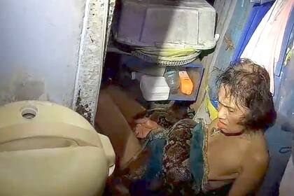 En esta fotografía proporcionada por Kunyakit Thanawtchaikun se muestra una pitón envolviendo el torso de Arom Arunro en el piso de su cocina en la provincia de Samut Prakan, Tailandia, el martes 17 de septiembre de 2024. (AP Foto/Kunyakit Thanawtchaikun)
